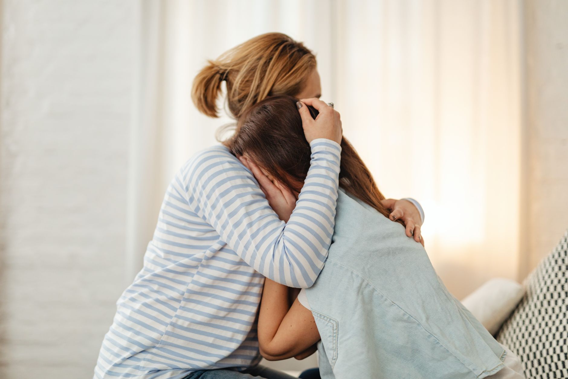 A parent comforting their teenage child at home.